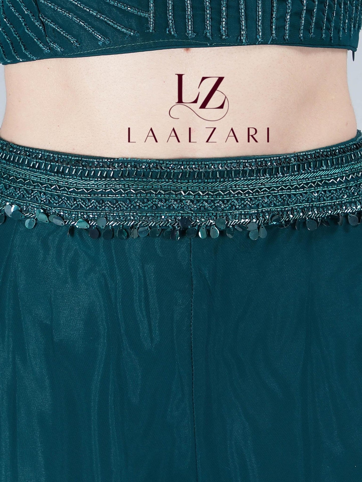 -Featuring a classy teal embroidered crop top in an imported georgette fabric base with silky shiny black lustrous threads. It is paired with a matching subtle skirt with a designer veil.